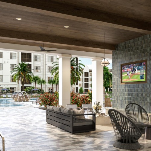 an outdoor lounge with a tv and seating near a pool